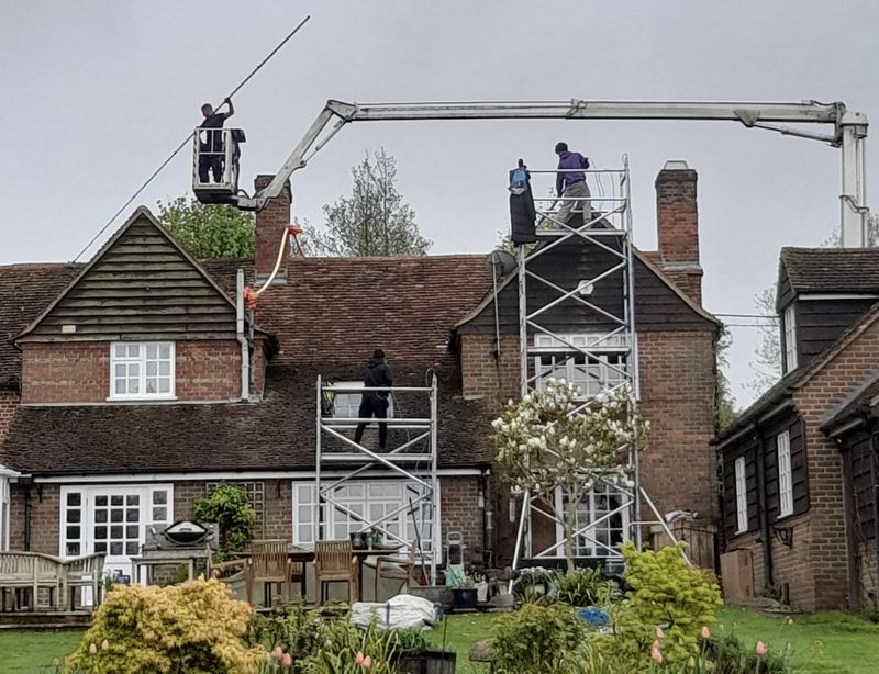The Moss Cleaners using cherry picker and scaffolding to clean roof safely and professionally in Stroud, Gloucestershire